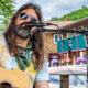 Gregg " Cheech" Hall playing acoustic guitar and singing.