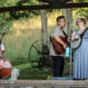 Crooked Willow, a folk pop band plays their music outside on a stage.